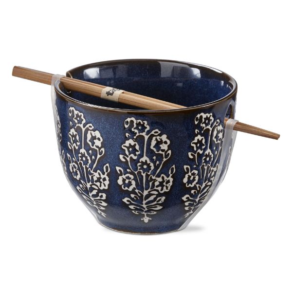 blue noddle bowl with floral design and chopsticks resting across it.