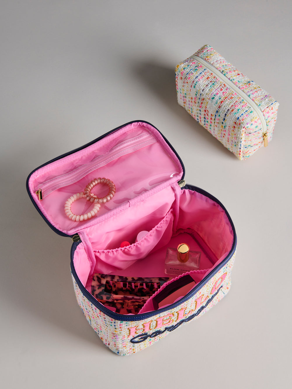 Cosmetic case open showing the hot pink interior with items in it
