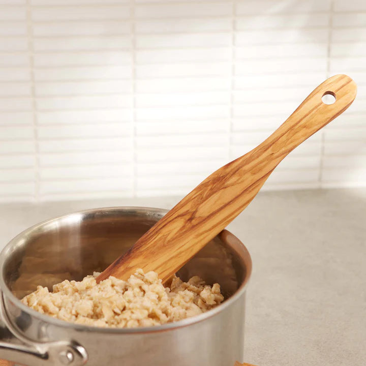olive wood spurtle in a bowl of oatmeal
