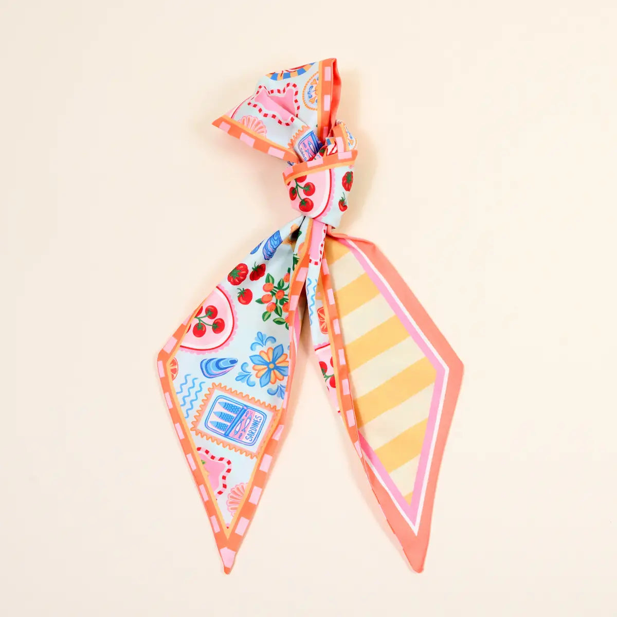 Colorful patterned scarf tied in a knot on a beige background