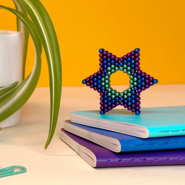star shape set on a stack of books next to a plant