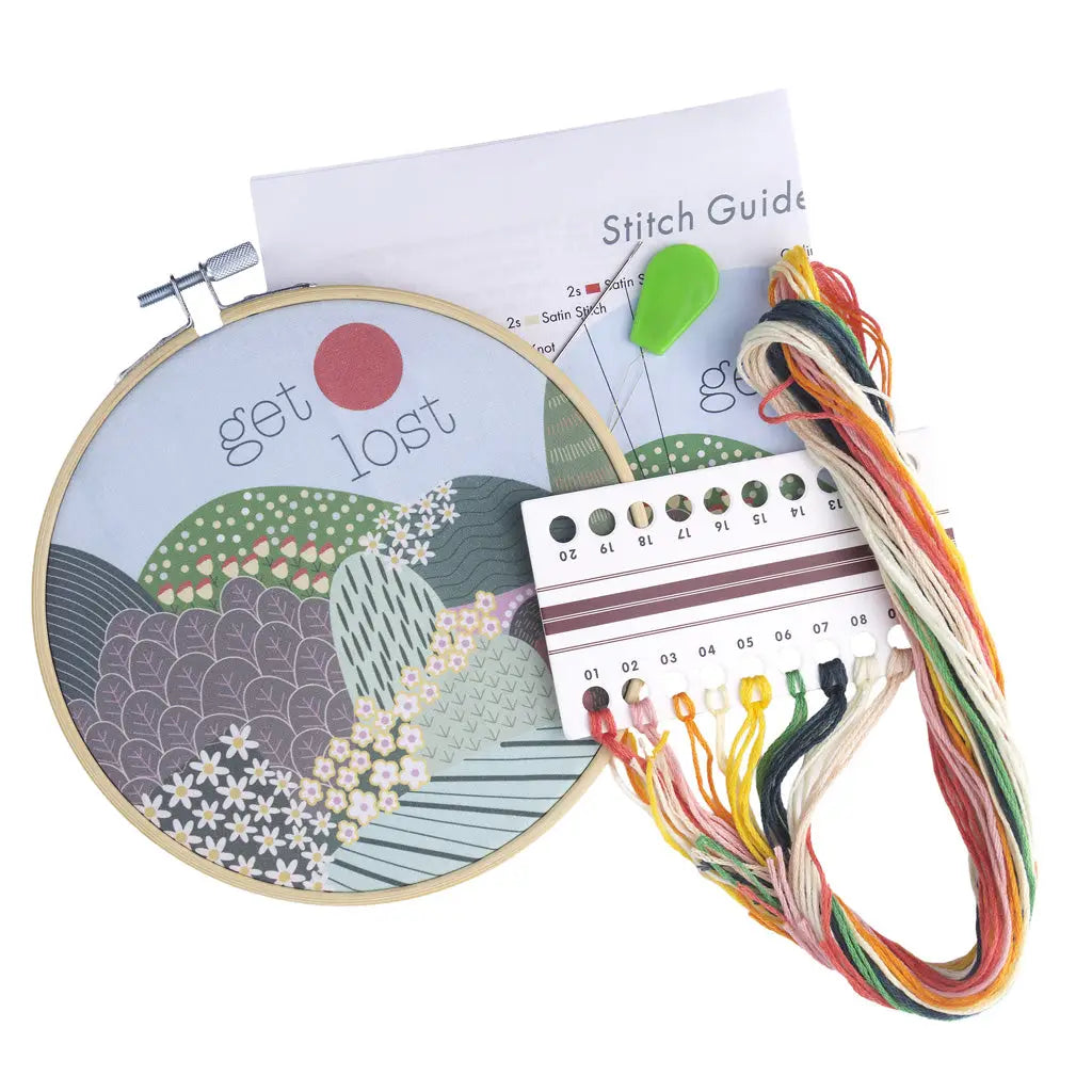 Embroidery hoop with colorful thread set and stitch guide on a white background