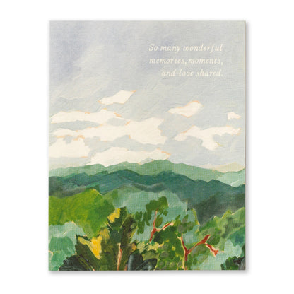 front of card has water color illustration of mountains and the sky, and white text listed in the title