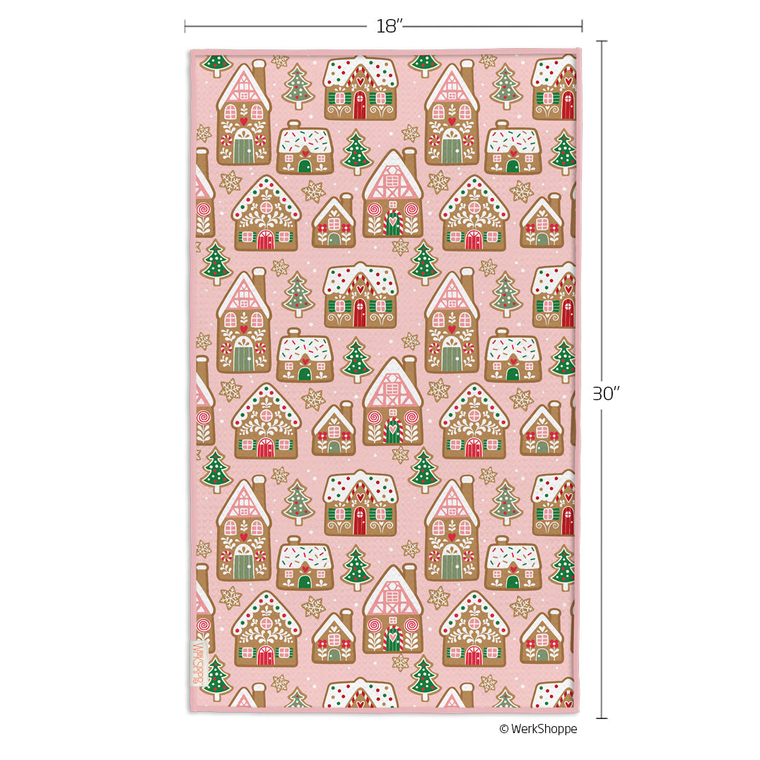 Pink towel with gingerbread house pattern and measurements on a white background
