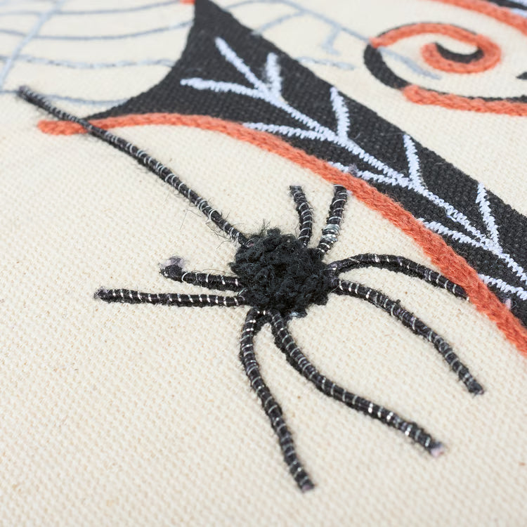 Embroidered spider on fabric with spider web design