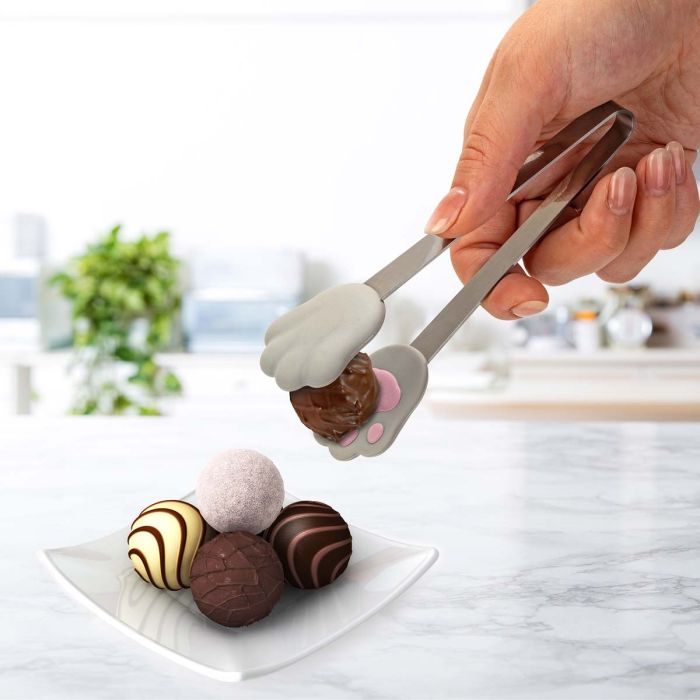 hands use cat paw tongs to pick up candies