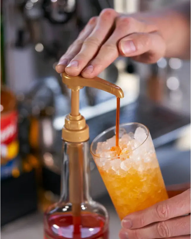 a person using a torani pump on their syrup bottle