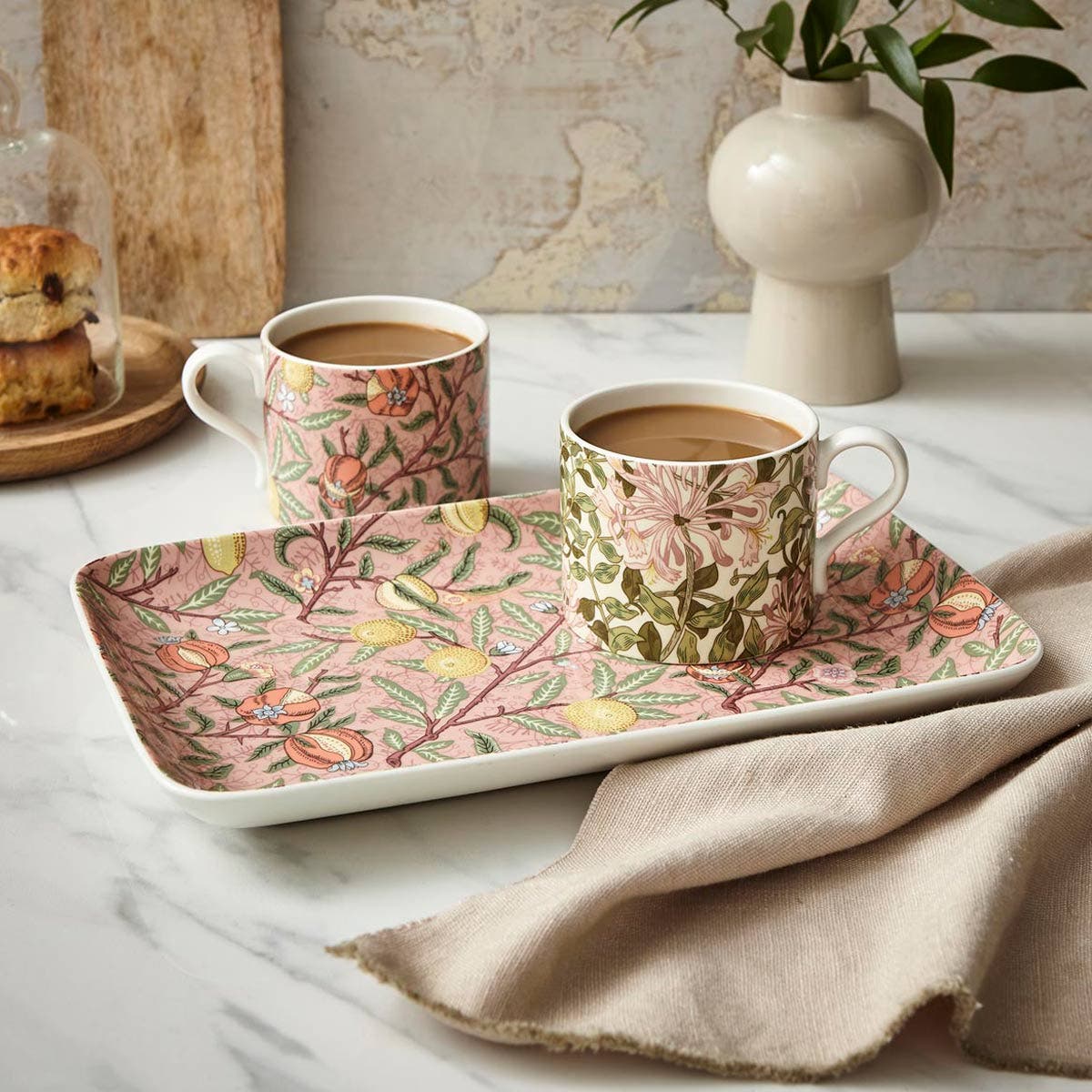 fruit serving tray in a decorated setting with 2 mugs filled with coffee