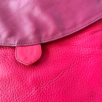 close-up of greta bag with plum flap over fuchsia body.