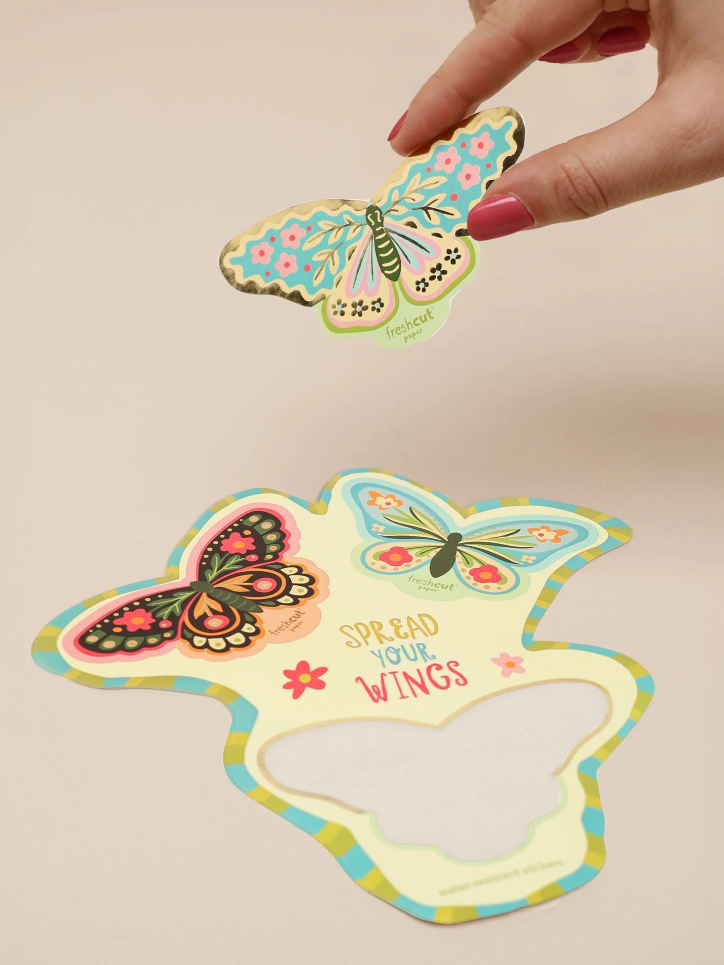 hand holding colorful butterfly sticker