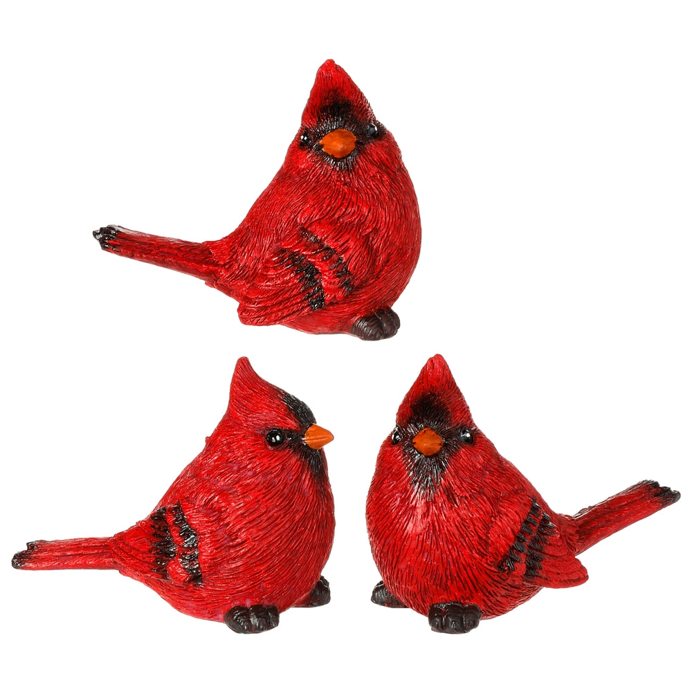 3 red cardinals made of resin arranged on a white background