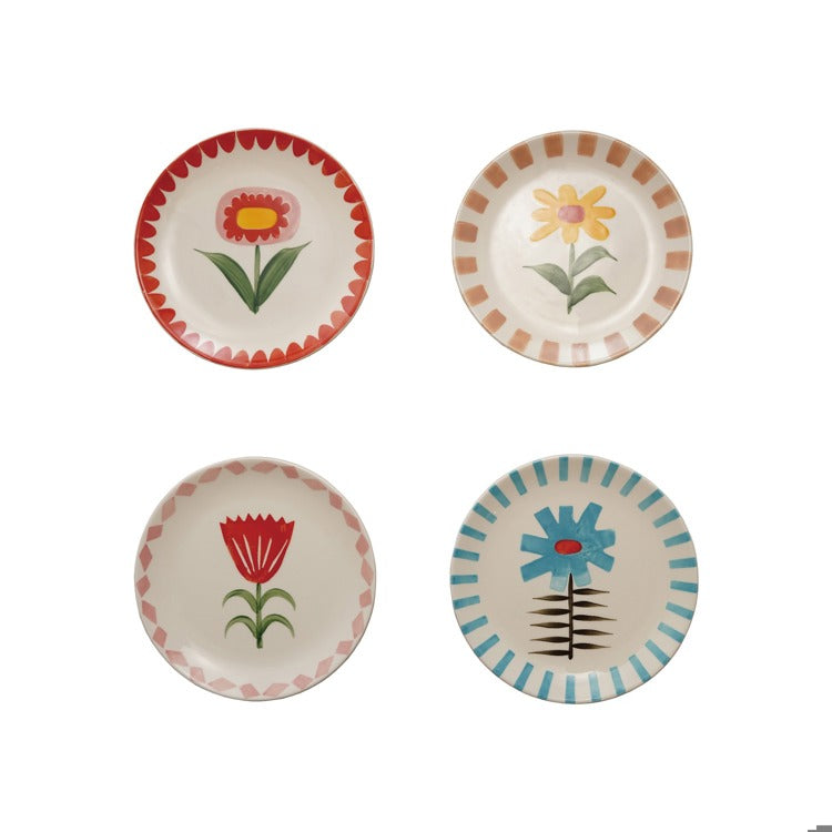 Four ceramic plates with floral designs on a white background