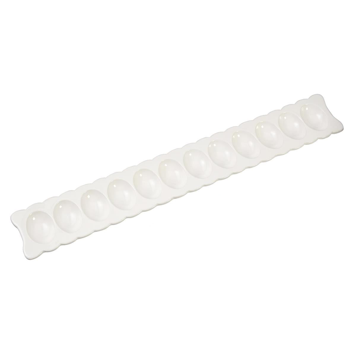 scalloped egg tray and serving fork on a white background.