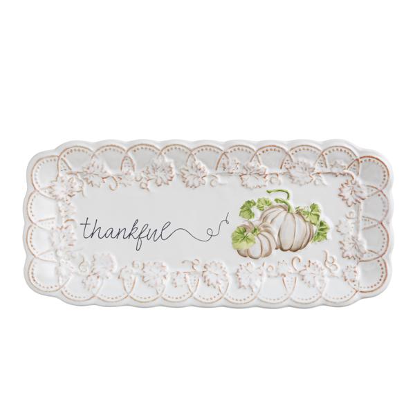 Decorative plate with a white pumpkin design and 'thankful' text on a white background