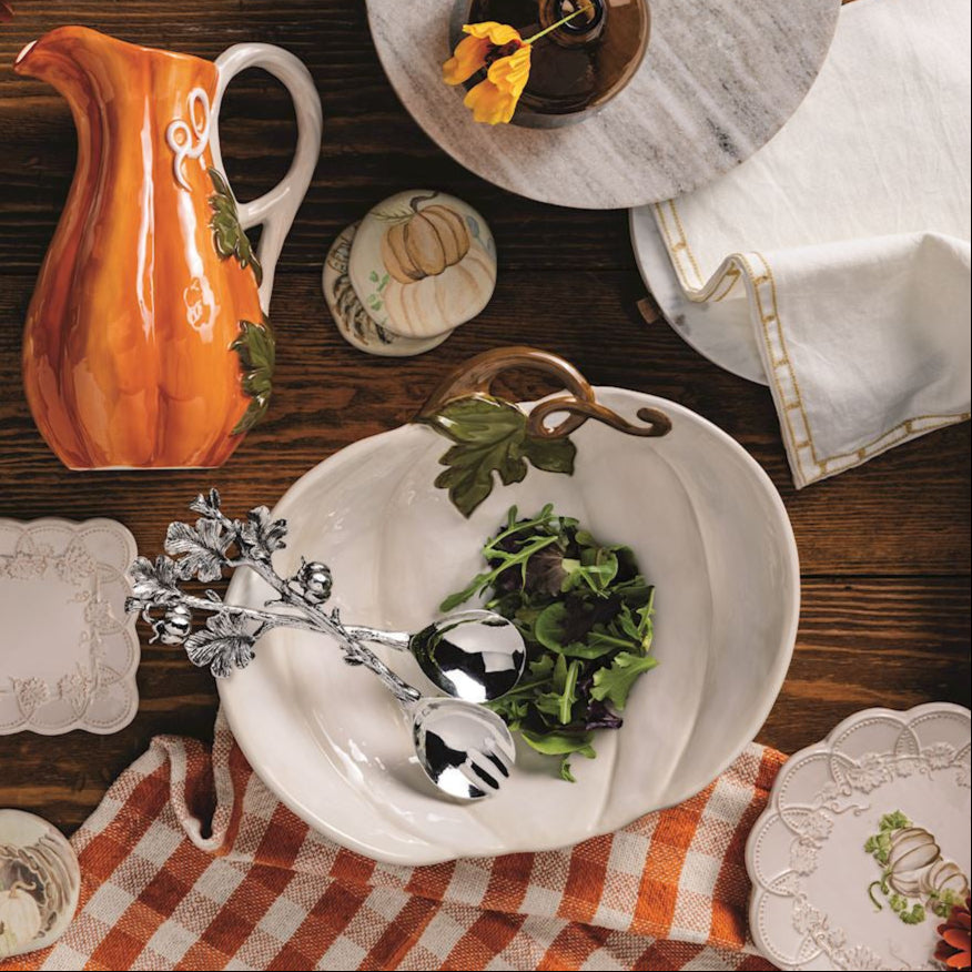 top view of table with white pumpkin bowl with salad in in it - other dishes are arranged on the table