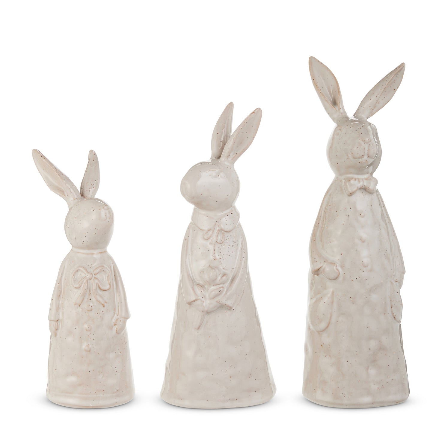 3 cream colored ceramic textured rabbits in frocks stainding against a white background
