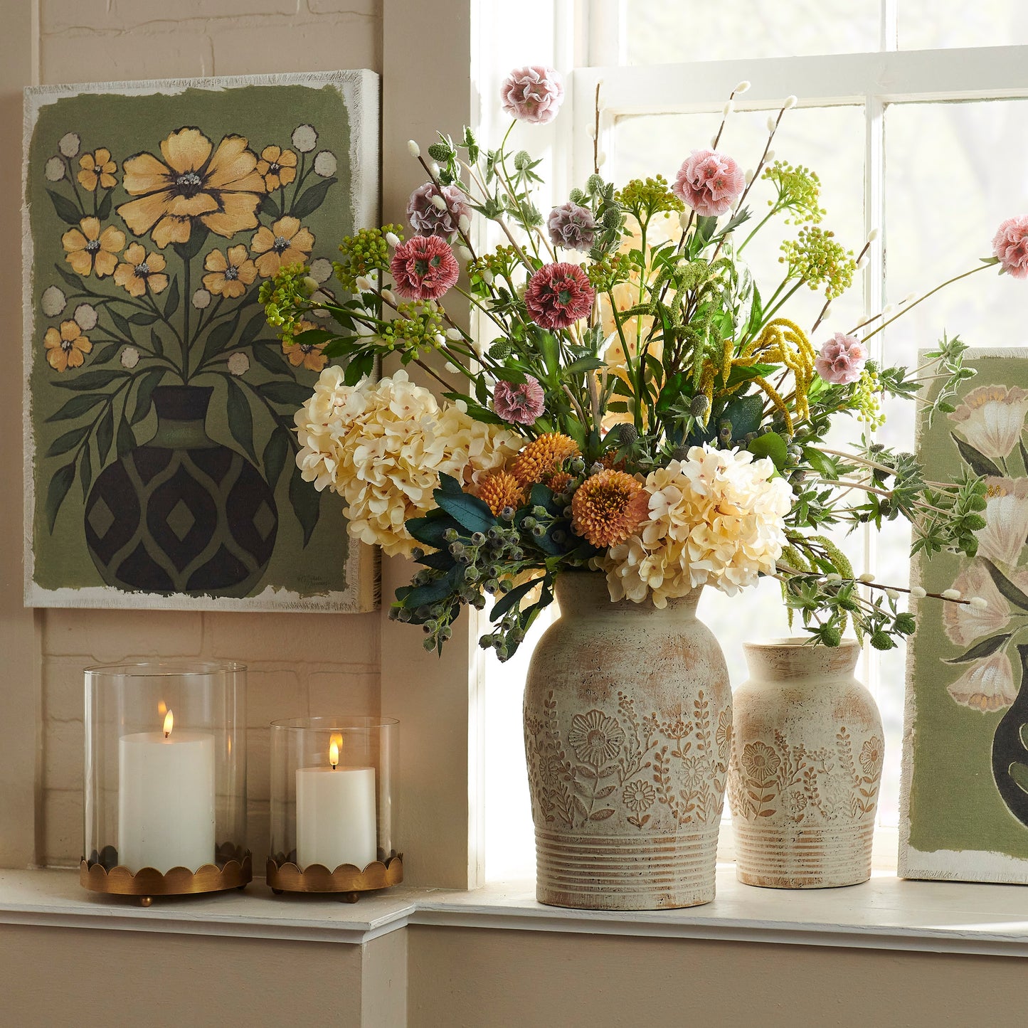 whitewashed floral embossed vase filled with a vibrant arrangement