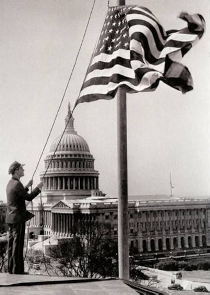 front of card is man raising american flag on a pole in front of the capitol