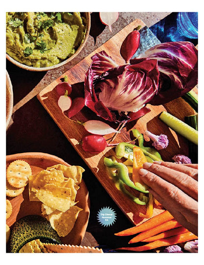 top view of a table arranged with chips, dips, and veggies.