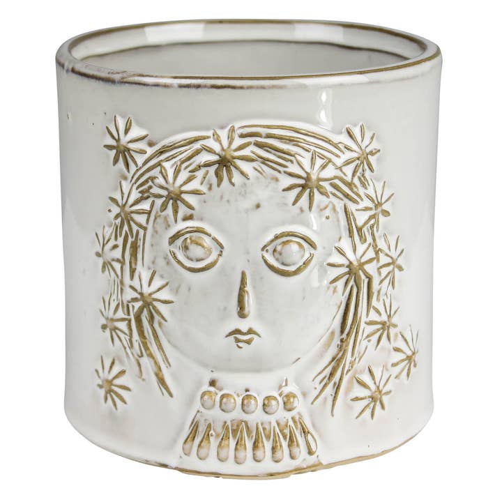 white ceramic pot with face and hair with flower designs in it