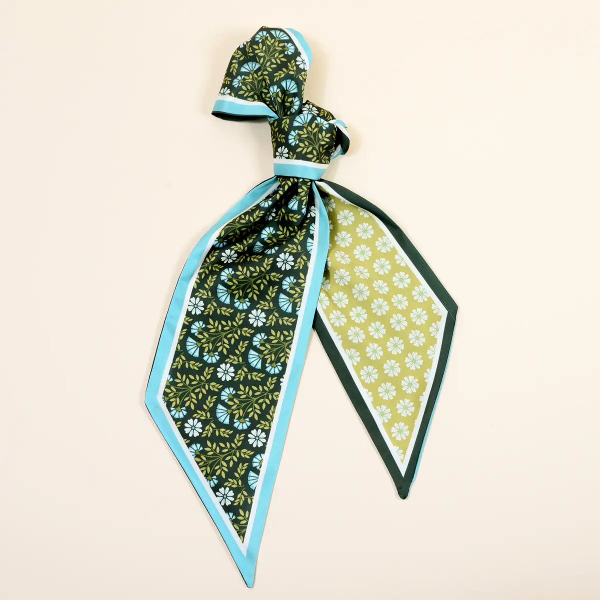 green scarf with green floral patterns on a beige background