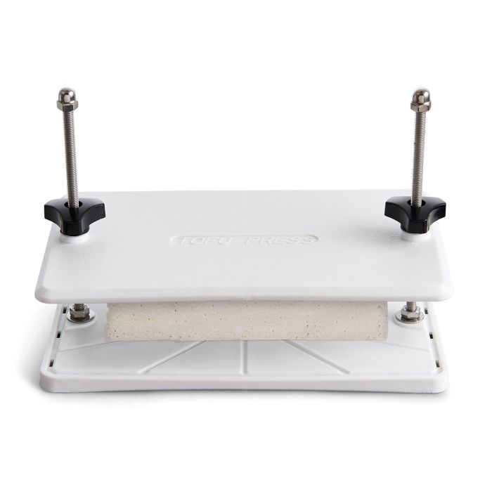 tofu press with tofu in it shown on a white background