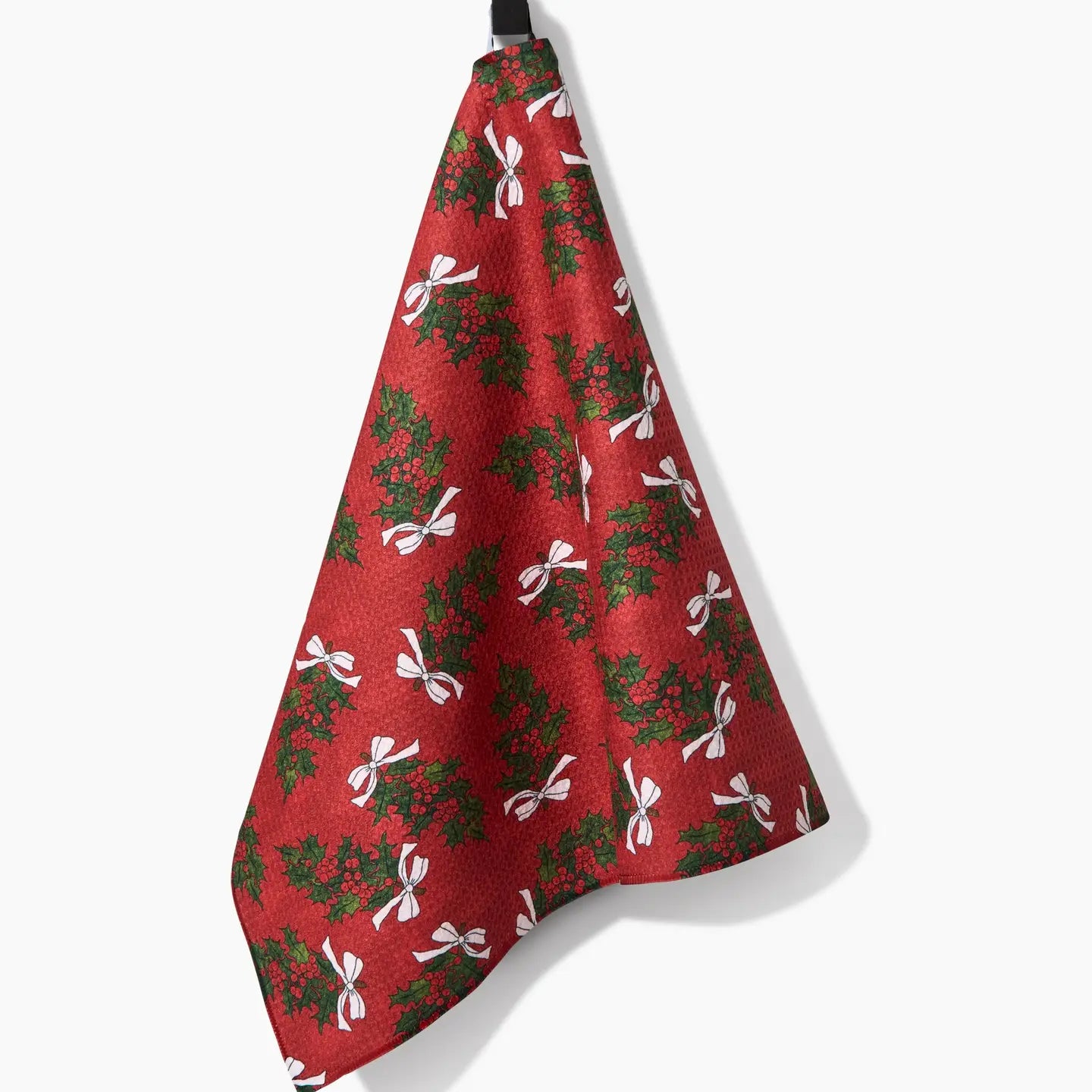 Christmas Berry Bow Tea Towel draped on a hook