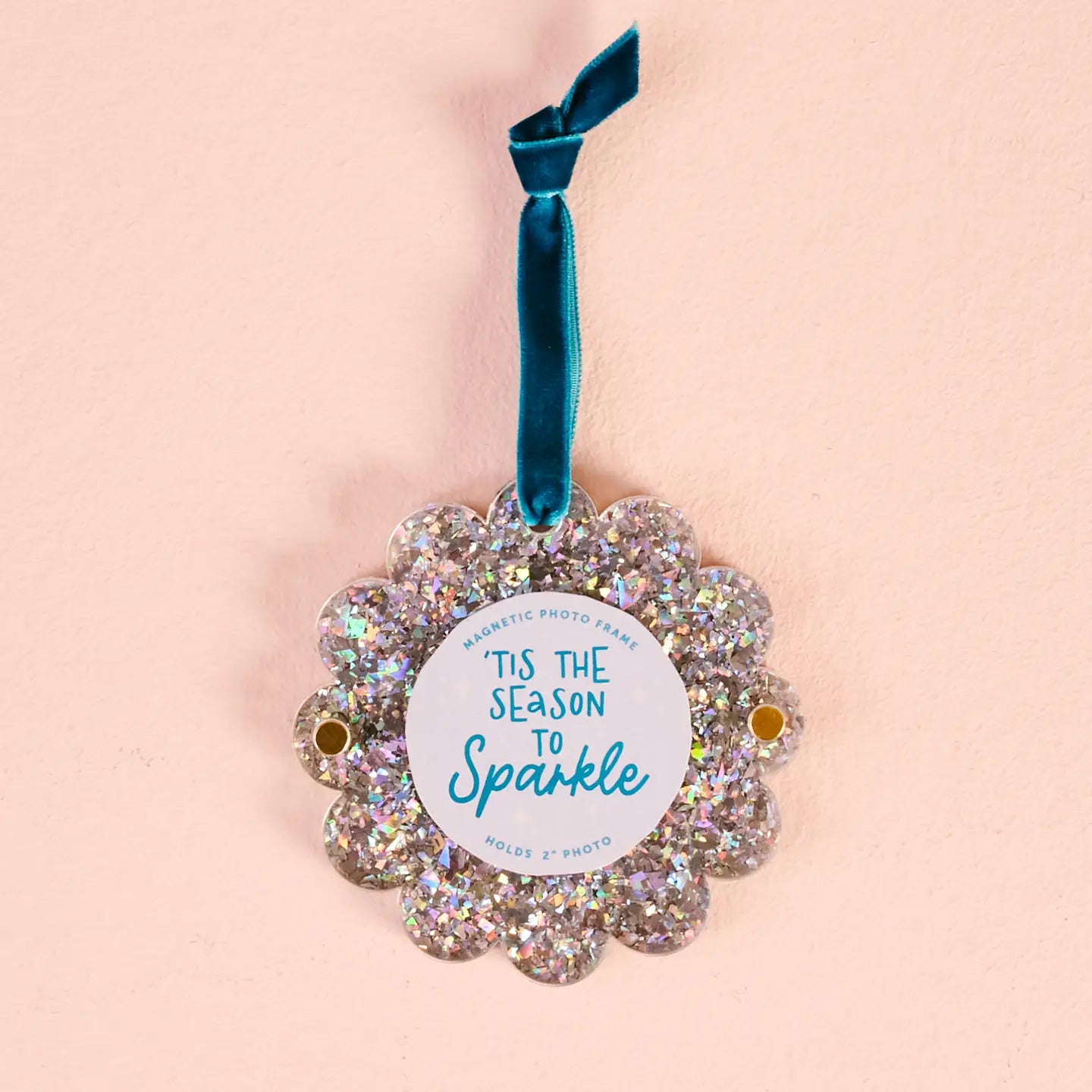 silver glitter Scalloped Acrylic Frame Ornament with a blue hanging ribbon shown on a beige background