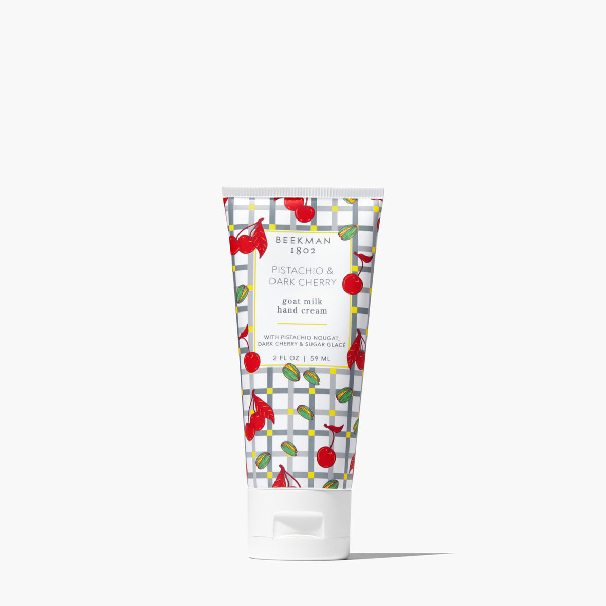 tube of Pistachio Dark Cherry Hand Cream printed with a cherry, pistachio and grey grid design
