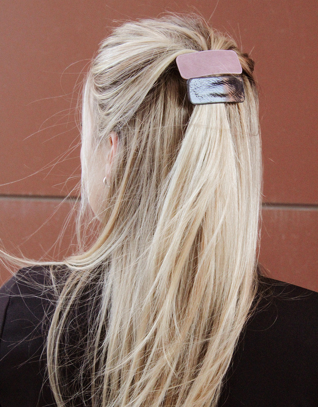 person with long blond hair clipped with 2 barrettes.