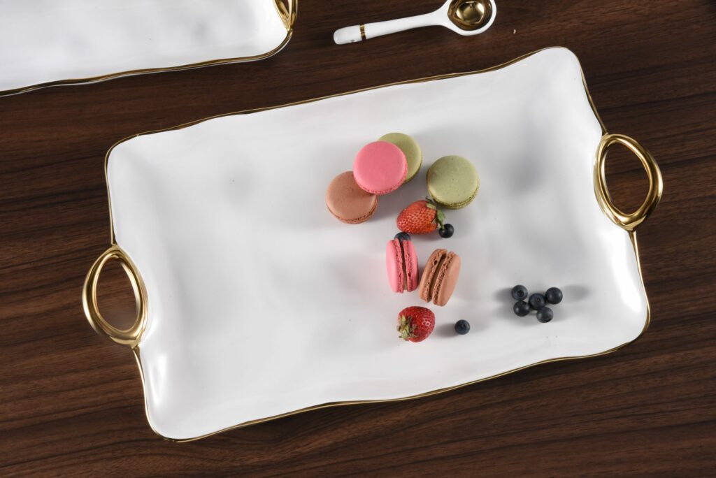 top view of white trayw ith gold handles that has several coolies and berries arranged on it.