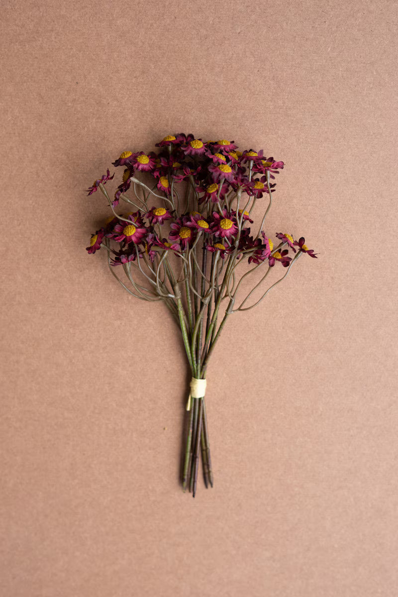 Bouquet of mini burgundy flowers on a brown background