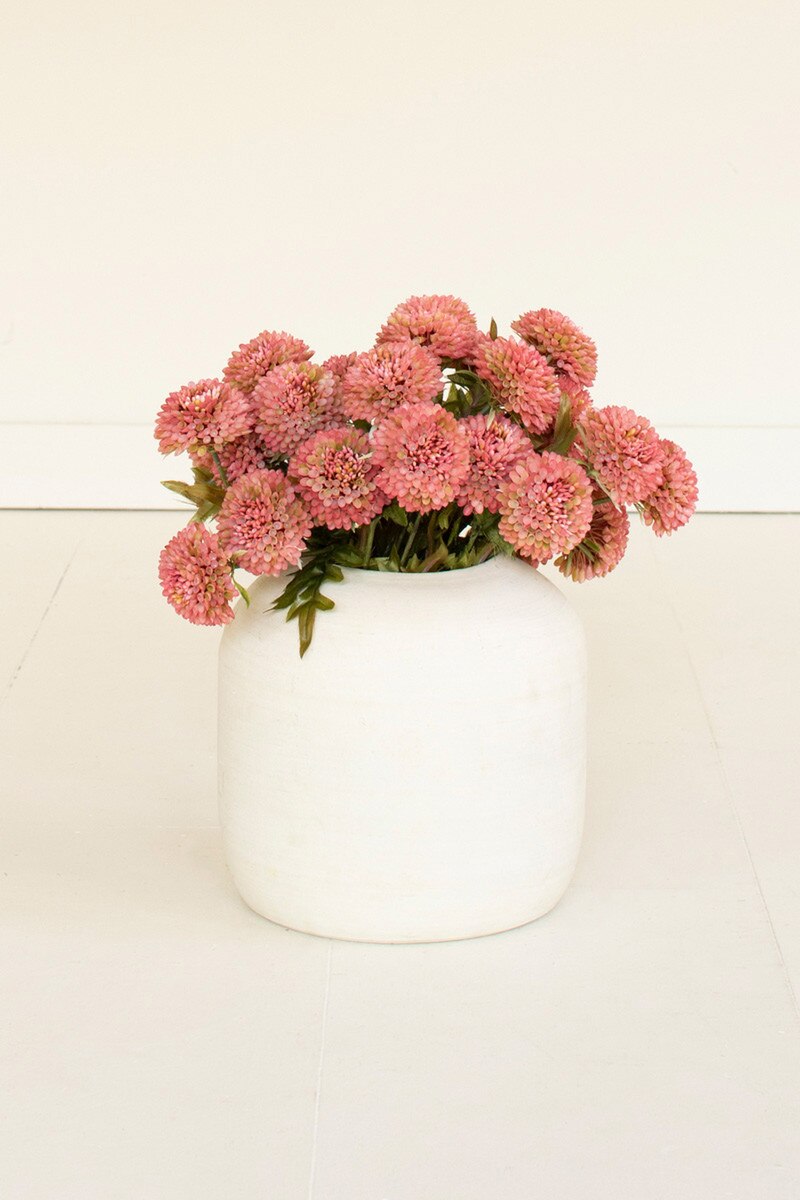 Pink flowers in a white vase on a light beige background