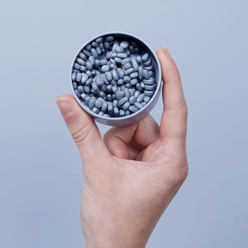 a hand holding the Slate crags inside the slate colored tin