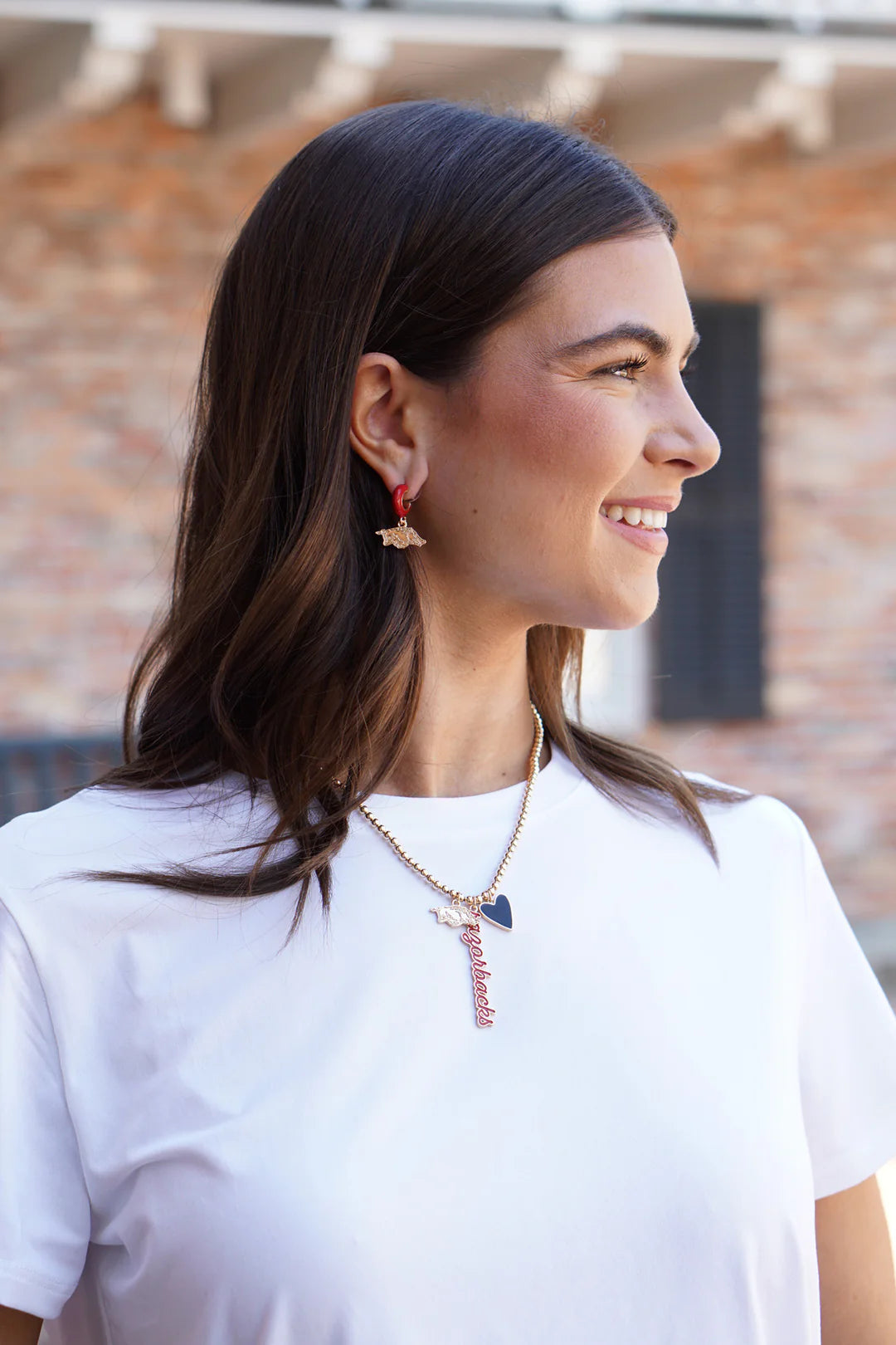 smiling person wearing Arkansas Razorback Ball Bead Charm Necklace