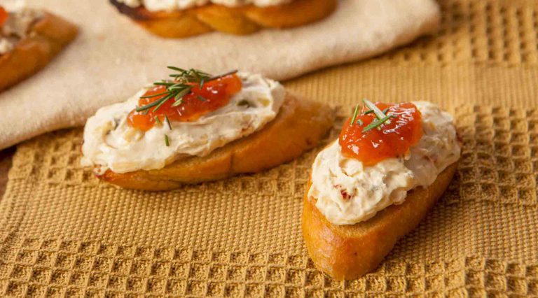 Jalapeno Peach Cheeseball & Appetizer Mix spread on little breads with jam on top