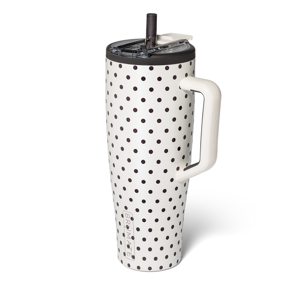 A white insulated travel tumbler with black polka dots, featuring a white handle, and a black lid and straw