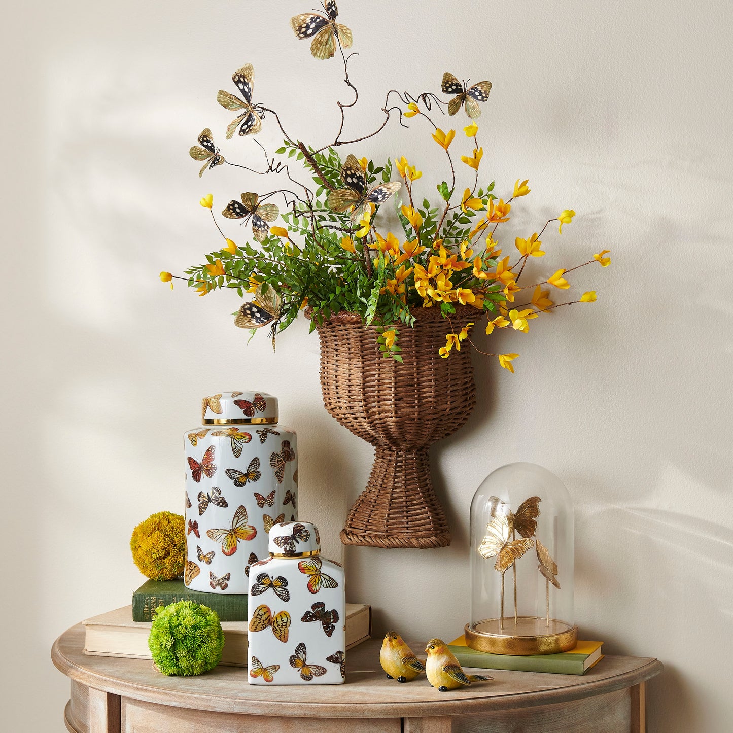 natural butterfly branch in a wicker vase with greenery and yellow flowers