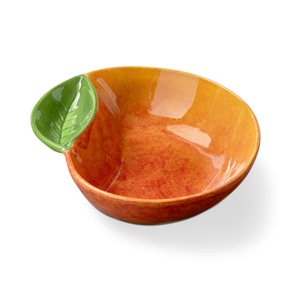 Orange ceramic peach shaped bowl with a green leaf on a white background