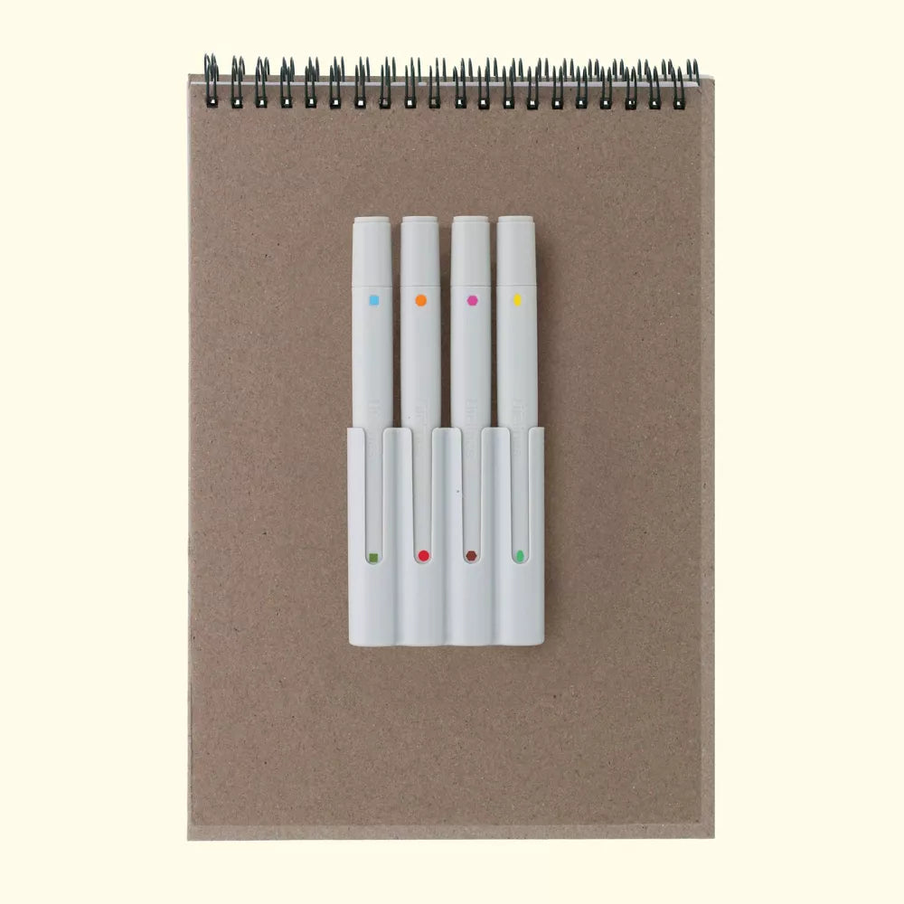 Notebook with a set of white markers on a beige background