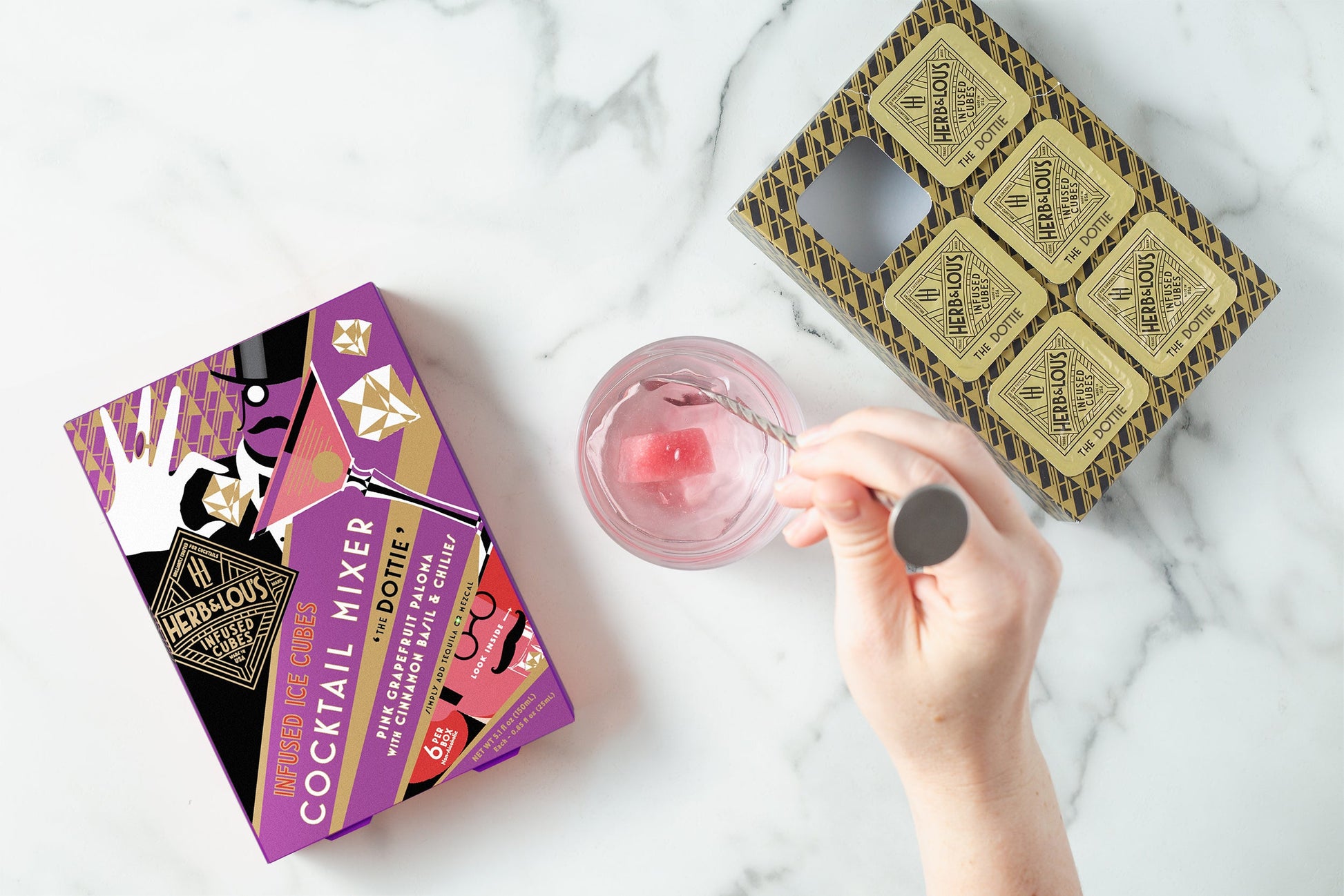 The Dottie  6 Cube Pack on a marble background with hand stirring a drink.
