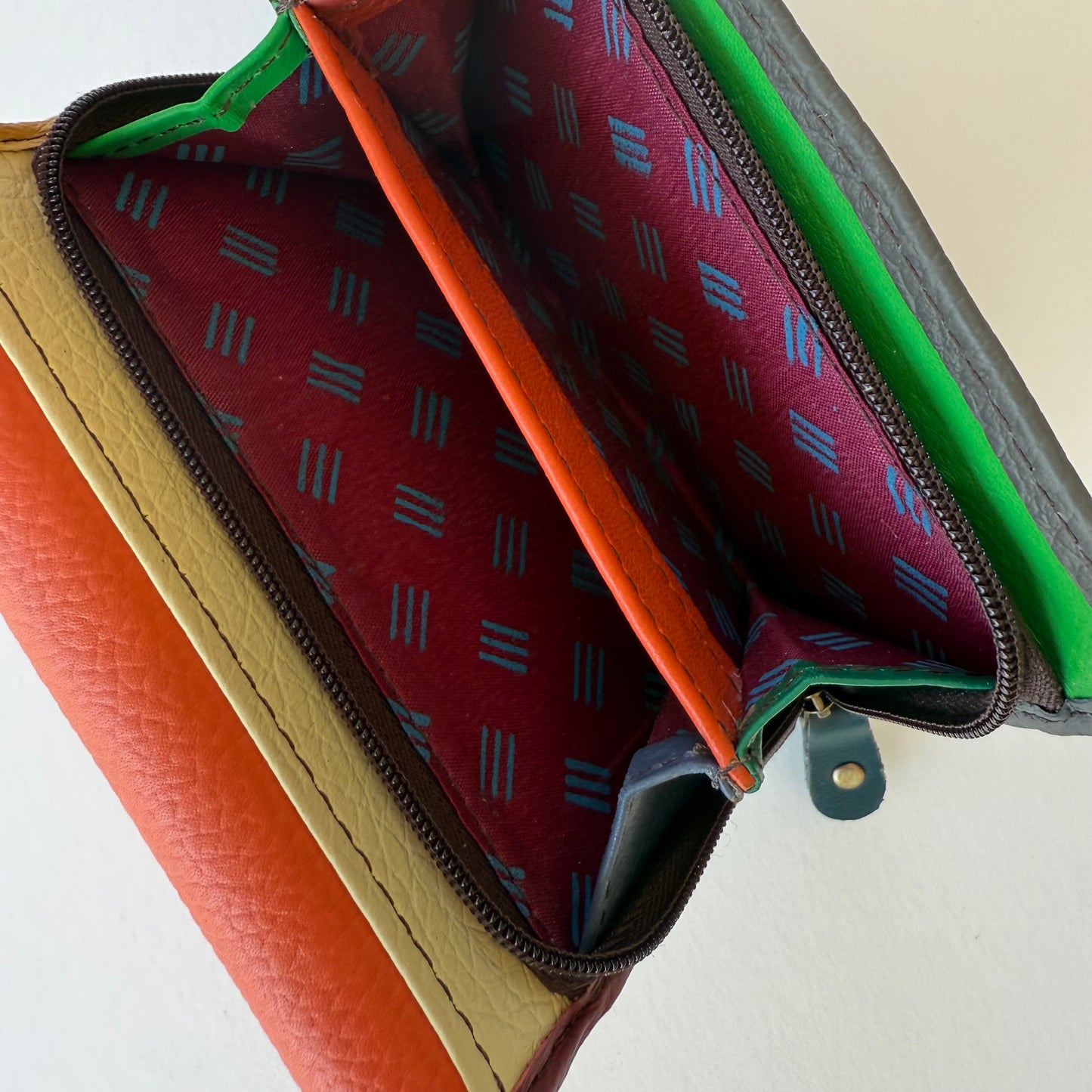 Close-up of a multicolored pouch with a patterned interior on a white background