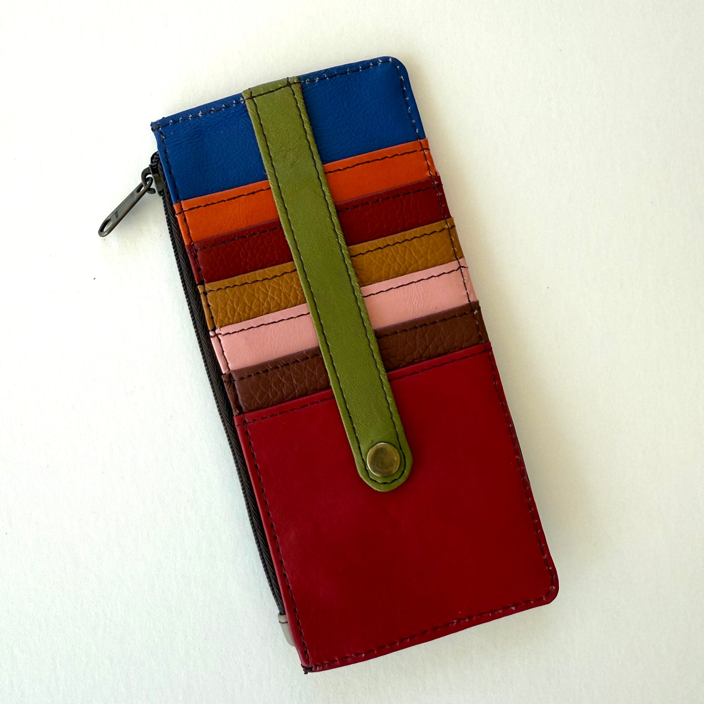 back view of Colorful striped wallet with a green strap on a white background