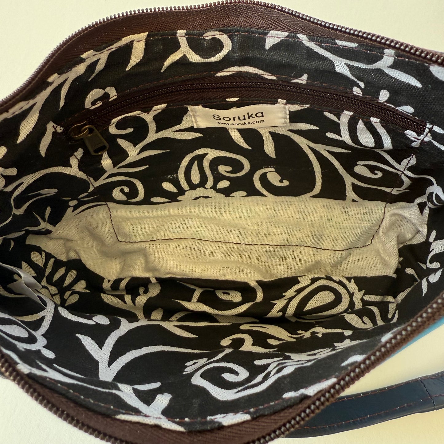 interior view of blue leather handbag with black and white patterned lining