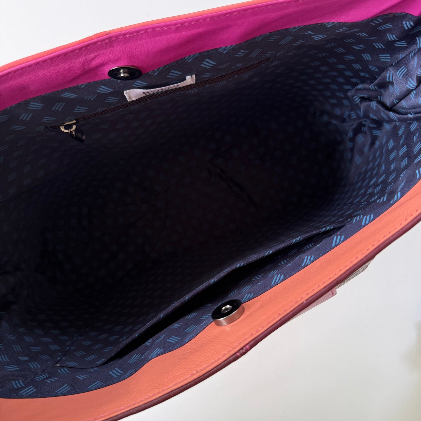 interior view of tote bag with navy patterned lining and pockets