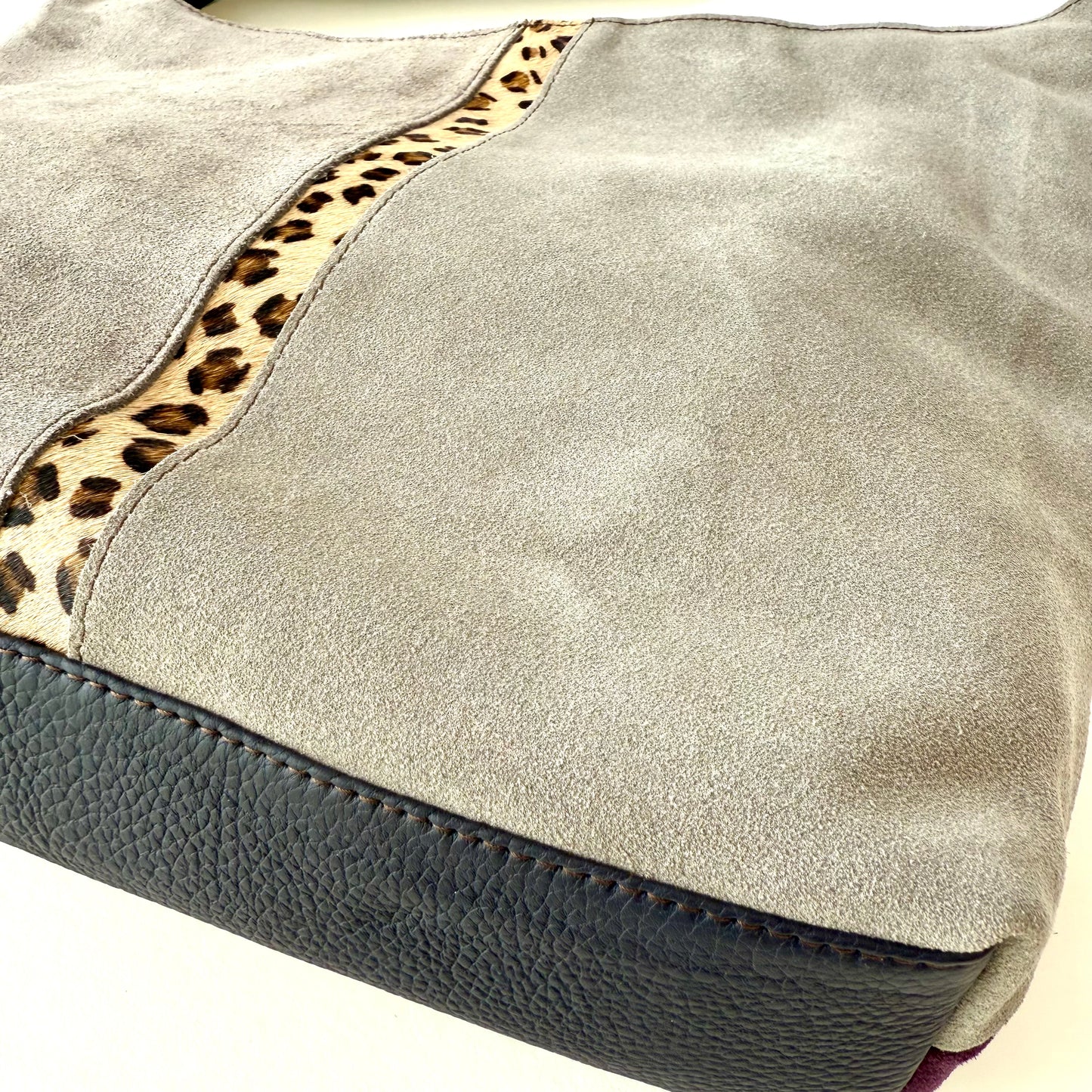 Close-up of a gray bag with leopard print trim on a white background