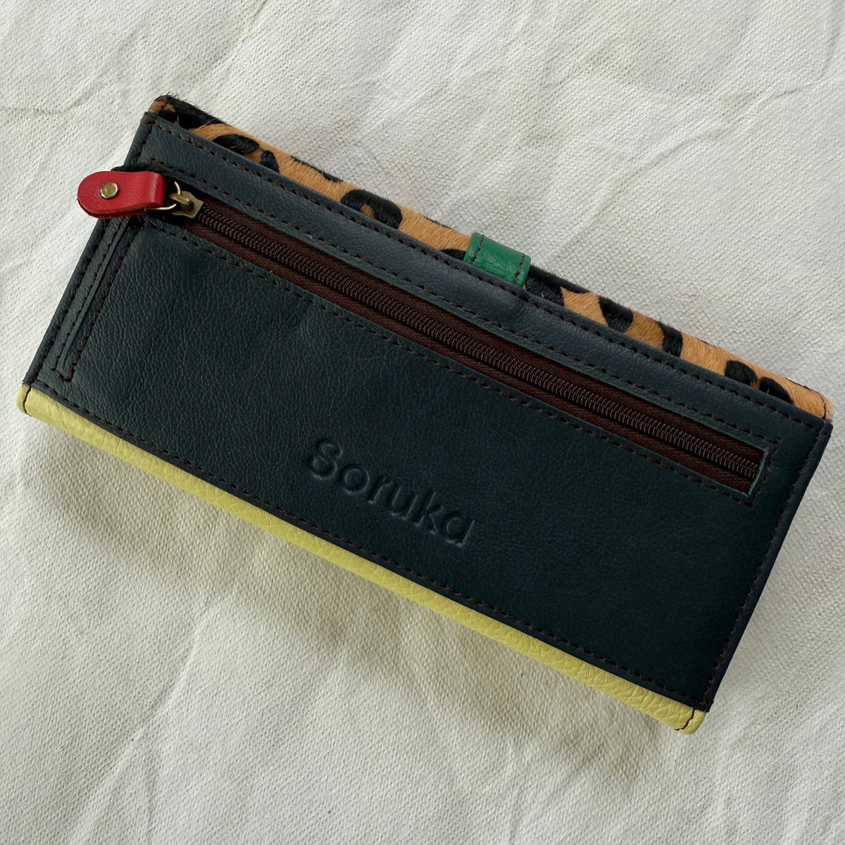 back view of wallet with deep navy backing and zippered pocket