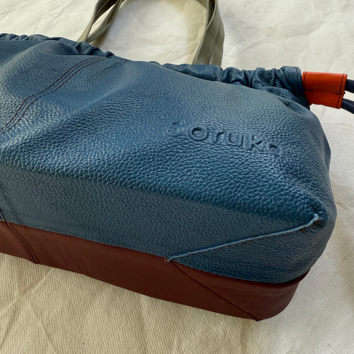 bottom view of burgundy and blue handbag