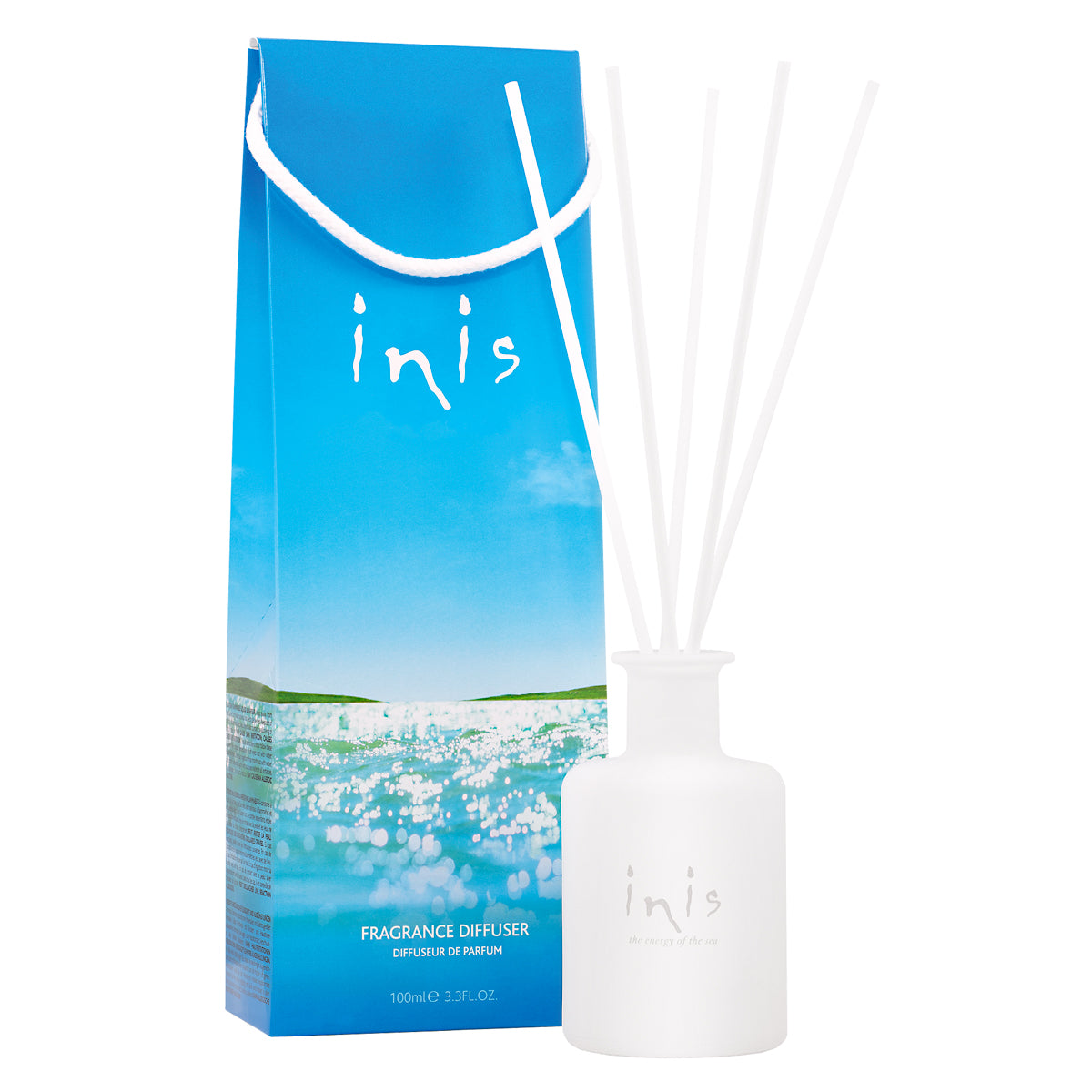 bottle of inis fragrance with reed diffusers on it set next to its box packaging.