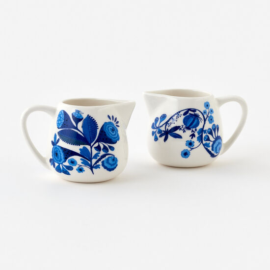 2 Blue & White Creamer Pitchers set on a white surface
